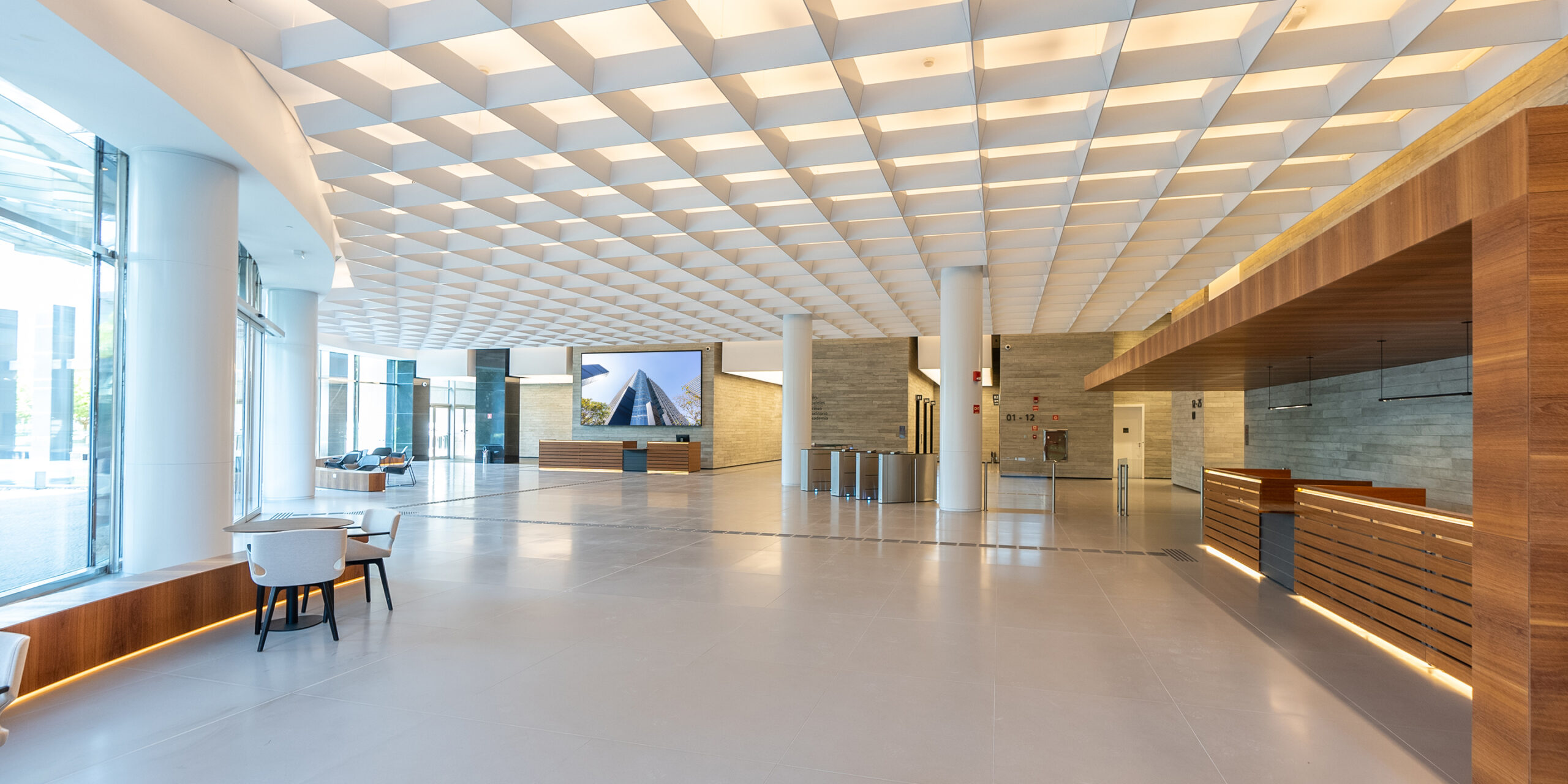 Lobby com duas recepções e ampla área iluminada